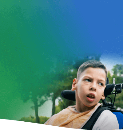 Young boy in electric wheel chair featuring a headrest looks off camera with alert expression